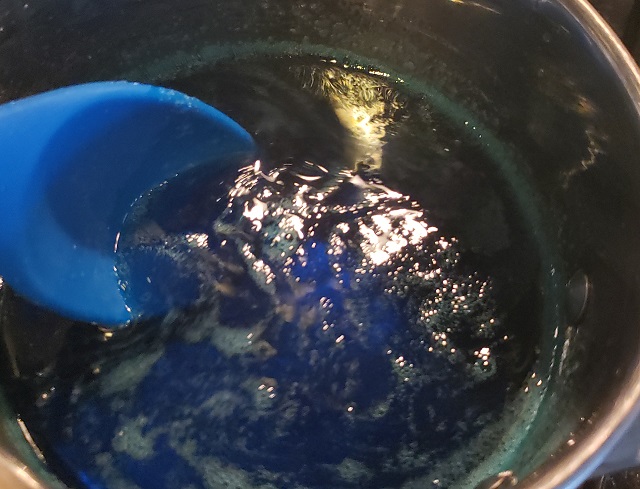 ロックキャンディの実験で小鍋で砂糖を溶かし青いフードカラーリングを追加