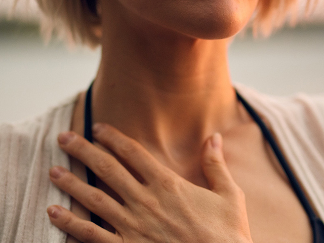 A woman holding her hand on her chest